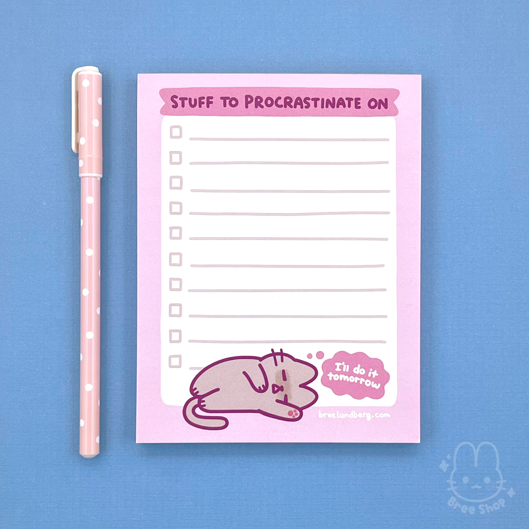 Photo of a lined notepad with a pink border and words at the top say “stuff to procrastinate on”, at the bottom is cute illustrated grey kitty sleeping on its side with a thought bubble saying “I’ll do it tomorrow”.